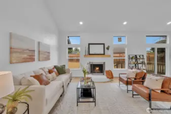 A brick fireplace serves as the room's focal point, framed by windows that offer views of the private fenced yard.