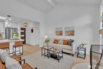 From the living area, the home's open flow is evident with clear sightlines to the kitchen island and front entry.
