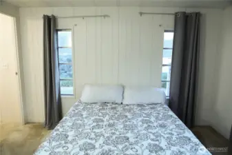 The main bedroom boasts stunning views of Lake Chelan, carpeting, and a spacious private ensuite for ultimate comfort and privacy.