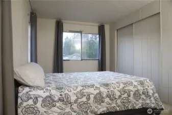 Another perspective of the main bedroom highlights the spacious closet and abundant natural light streaming through multiple windows.