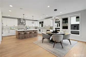 Modern dining area anchored by statement windows and lighting offering a seamless flow into the kitchen and great room.
