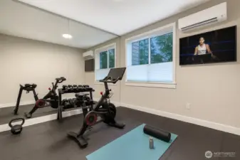 Virtually staged to showcase an ideal home fitness studio alternative complete with wall-to-wall mirrors, cushioned flooring, and space for strength, cardio, and yoga training. A perfect spot for Peloton sessions, free-weight workouts, and stretching routines.