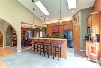 View of kitchen and dining room. Open to great room and second set of french doors to side deck off to the right of this photo.