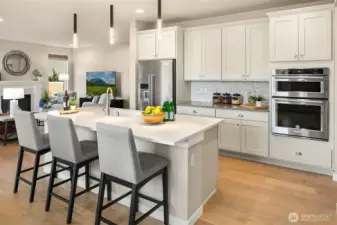 Eat in kitchen with breakfast bar at island and upgraded pendant lighting