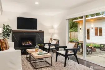 A comfortable and quiet family space decorated by the handsome back marble gas fireplace. In this photo you can see the finished ADU space just beyond the rear slider with corresponding exterior details.