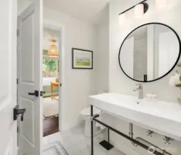 This downstairs guest bath offers a tile shower, shiny basin sink and handsome black fixtures with modern exposed plumbing features.