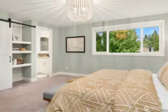 Looking toward the primary ensuite doorway and built-in closet storage with barn door feature.