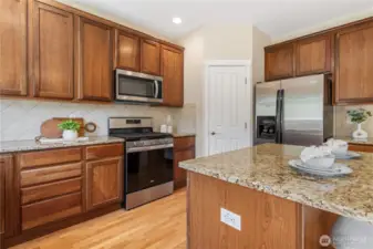 Enjoy this spacious kitchen with open sight lines to the family room! Large center island with breakfast bar seating, gleaming stainless steel appliances and a walk-in pantry
