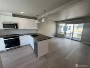 Bright, open floor place with slider leading out to spacious deck