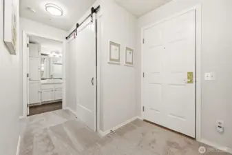 Front-load washer and dryer tucked behind stylish barn door.