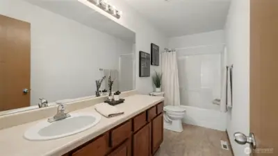 Generously sized with elegant finishes, this bathroom combines a large vanity with a relaxing tub for everyday convenience and luxury.