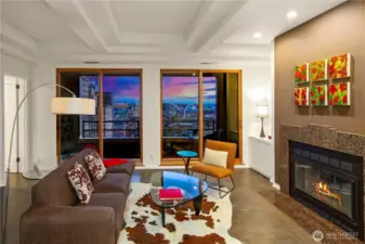 Anchoring the residence, the penthouse living room frames the southern skyline through tall windows while a wood burning fireplace establishes warmth and proportion.