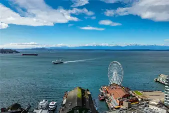 Elliott Bay stretches westward where ferries trace their daily crossings toward Bainbridge and Bremerton beneath an open maritime horizon.