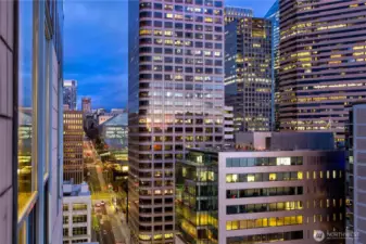 Evening light transforms the skyline into a quiet constellation of towers seen from the penthouse.