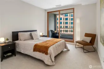 Large windows bring the surrounding skyline into the bedroom while maintaining calm above the streets below.