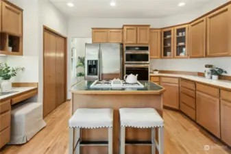 A light-filled kitchen features a brand-new stainless-steel oven and microwave, a dining nook, plenty of workspace, storage, and a breakfast bar.