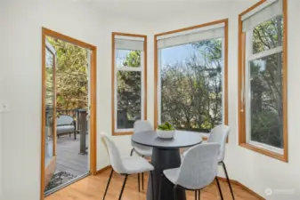 The Kitchen dining nook pverlooks a deck and lush backyard trees.