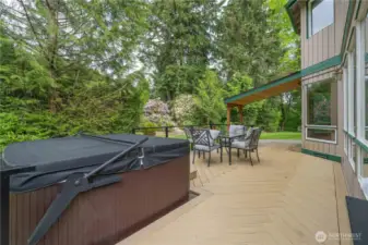 Large herringbone deck features family sized hot tub with "easy assist" lid, lots of room for seating, and covered barbecue area for year-round barbecuing.