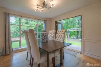 Dining room with Pella double doors that open to the cedar porch and pergola with raised fire ring.