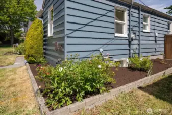 Beautiful garden beds that surround the home, adding vibrant color and natural charm. Plenty of gardening opportunities to cultivate your own green oasis