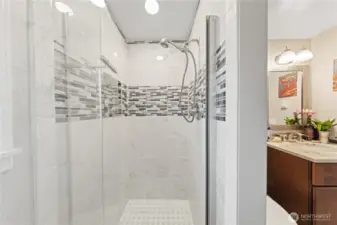 Updated 3/4 bath features glass door and modern tiles.