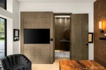 Floor to ceiling windows, white oak paneling and built in tv in the handsome office/den.