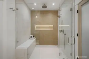 Primary bathroom featuring this stunning walk in shower bench, rain shower and porcelain tile with built in product holder and motion sensor lights.