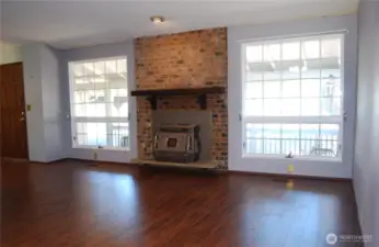 View in to the living room with hand scraped style wood flooring and a wood burning stove to provide peace of mind in emergencies.  This home blends functionality with location—what an opportunity!