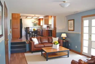 Virtually staged view across the family room with laminate flooring in to the kitchen.  Patio off family room is great for outdoor entertaining, BBQs, or simply relaxing. Plenty of backyard space for an RV and backyard fun, includes shed.