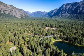 Aerial view of the home, Wilson Ranch Community & Freestone Inn—surrounded by towering peaks, lush forest, and featuring Freestone Lake just steps away. A rare opportunity in the heart of Mazama’s recreational paradise.