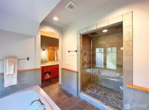 Spa-like ensuite bath with jetted tub, tile shower, and dual vanities.