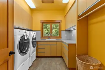 Generous laundry room with built-in cabinetry and natural light.