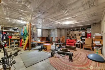 1,310 SF unfinished basement with high ceilings, storage, and wine nook.