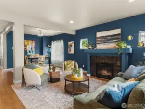 Large family room with fireplace and lots of natural light opens into the dining and the kitchen area.