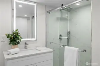 Lower level bathroom with custom heated tile floors and washer and dryer.