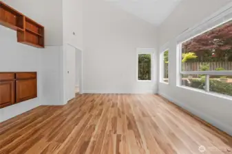 Living room with built in wood shelving and views to backyard