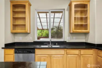 The kitchen look out to the covered hot tub area.  (Inspection report recommends removal).