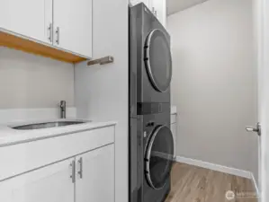 Across the hall is the upgraded laundry room with built in laundry center, utility sink and an abundance of additional storage space.
