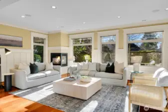 Sun drenched formal living room overlooks the fenced in back yard