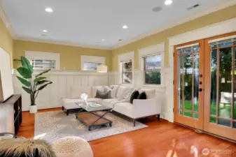 The family room is adjacent to the kitchen and opens through French doors to the back yard and a covered patio area