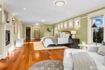 A look at the primary bedroom suite with gas fireplace, dual walk-in closets and an elegant 5-piece bathroom