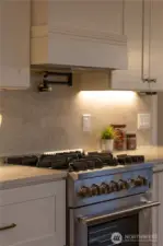 Chef-inspired kitchen with professional gas range, pot filler, and refined finishes throughout, showcasing a level of craftsmanship that stands apart from typical Seattle remodels.