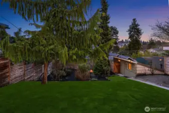 Spacious lawn, garage, with fire pit in the garden area.