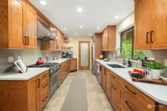 Newly remodeled kitchen with quartz countertops, Thermador appliances and a pantry at the end