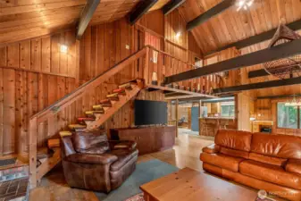 From the fireplace, your eyes climb the stairs and wander across the balcony that bridges the upstairs rooms. Wood beams frame the view like lines in a sketch, every angle a little unexpected. Even the walkway itself feels like it has secrets—linking bedrooms with a tucked-away Jack & Jill bathroom in between.