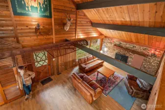 From the balcony, the lodge shows off its quirks—native artwork glowing in the spotlight, stretched across a high window like a tapestry. Just below, the canoe rests in quiet retirement, while the deer keeps its post. And below? Madeline stands ever-watchful, making sure you don’t miss a thing.