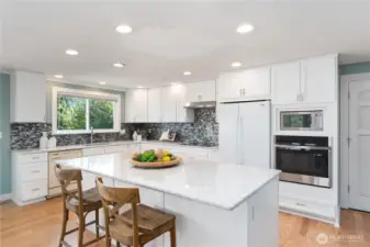 Updated kitchen w/ quartz counters, soft-close cabinetry, and new oven, microwave, and induction cooktop.