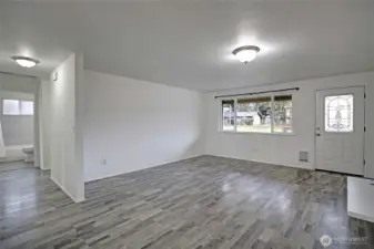 Easy maintenance laminate flooring throughout most of the home. View looking from dining room.
