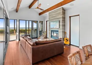 Soaring ceiling with custom fan and locally handcrafted venetian plaster fireplace surround and propane insert