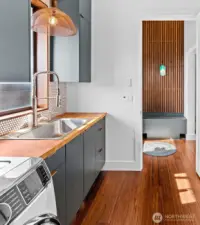 Main level utility room with under cabinet sweep vacuum